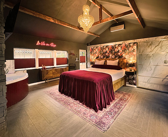 romantische boudoir suite overzichts foto met 2 persoons bed gouden kroonluchter en bloemenbehang