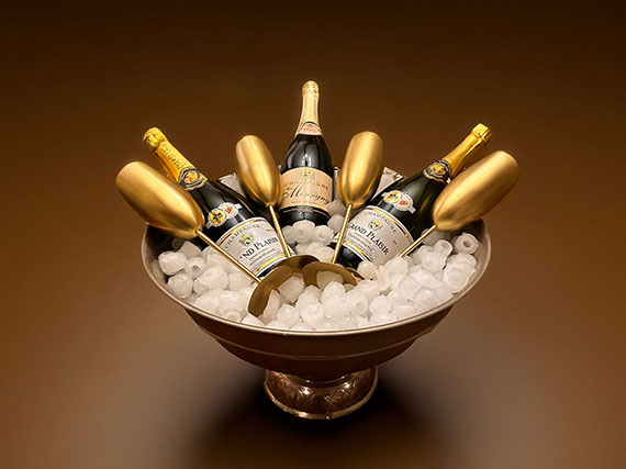 grote schaaalvormige chapgne koeler met 3 flessen champagne en 4 goudkleurige chapagne flutes in ijs